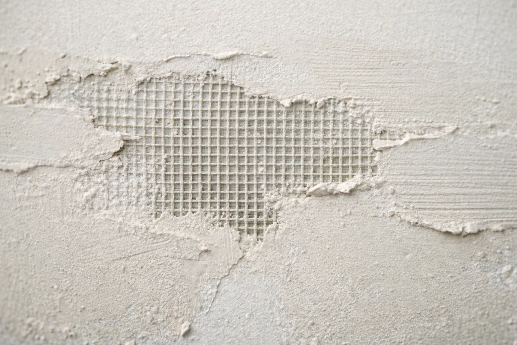 Example of over-sanded drywall patch showing mesh tape visible through compound
